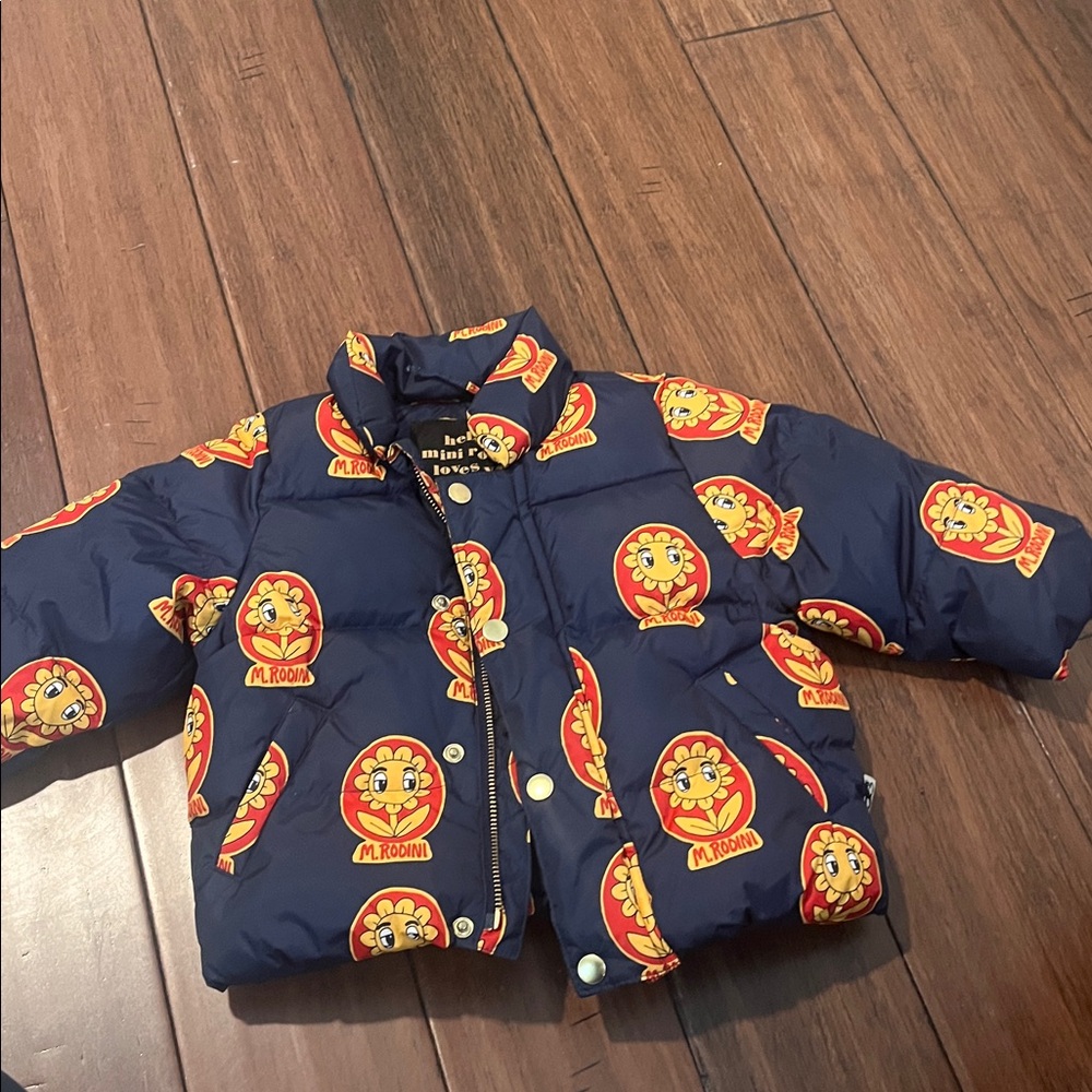 This is a Mini Rodini Alpine Flowers or Winter Flowers puffer jacket for kids.